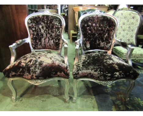 A pair of open arm chairs with overstuffed sprung upholstered seats and button backs within shaped carved and moulded frames 