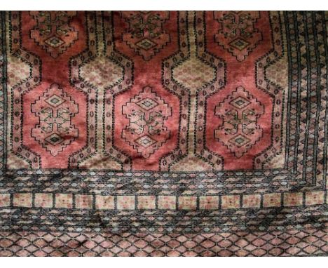 A good quality eastern carpet decorated with various block medallions upon a pink ground, 300 x 225 cm
