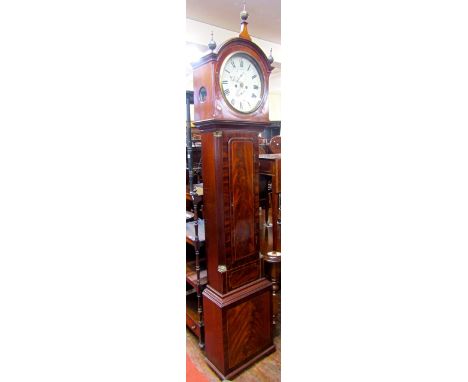 A regency mahogany long case clock, the trunk with flamed veneer within reeded and canted corner, the domed hood enclosing a 