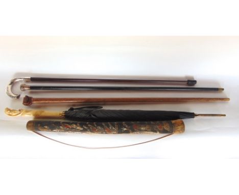 A collection of canes to include two silver topped examples, an exotic cane with clutched fist knop, a parasol with ivorine k