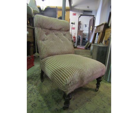 A late Victorian nursing chair with pink and cream striped upholstered seat and button back, raised on four turned legs with 