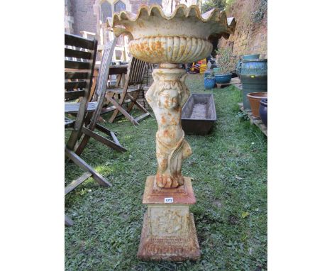 A cast iron planter, the circular shallow lobed bowl with crimped flared rim, raised on a standing cherub support and square 