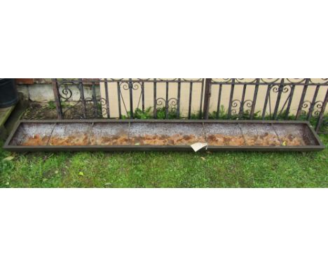 A vintage cast iron pig feeding trough with rung divisions, 245cm long (approx 8ft) x 30cm wide x 16cm deep