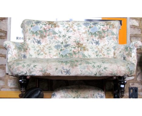 A Victorian two seat sofa, with shaped outline, swept and rolled back and arms raised on ebonised supports; together with a s