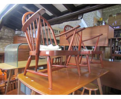 A pair of Ercol stained beech and elm lounge chairs with stickbacks and arms 