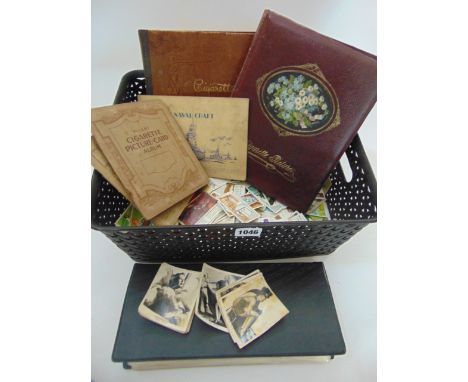 A box containing six cigarette card albums and further loose cigarette cards, together with two prints of waterfalls