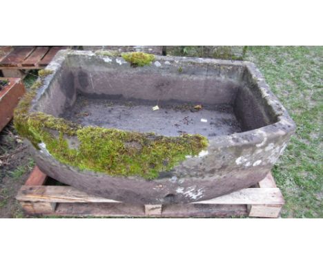 A good natural stone trough of rectangular form with single curved side, 106cm long x 80cm wide x 32cm high approx