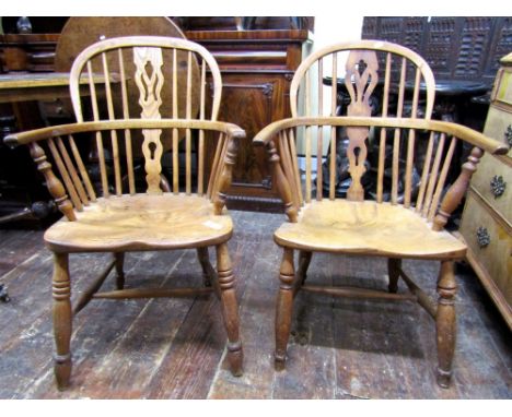 A pair of Georgian Windsor comb back elbow chairs, principally in ashwood with pierced splats, saddle seats, turned supports 