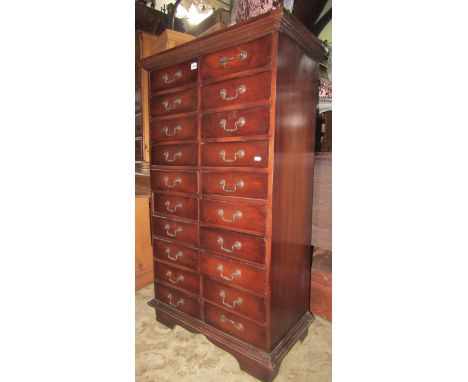 A reproduction hardwood upright chest, fitted with a side by side arrangement of 20 drawers, with swan neck handles and brack