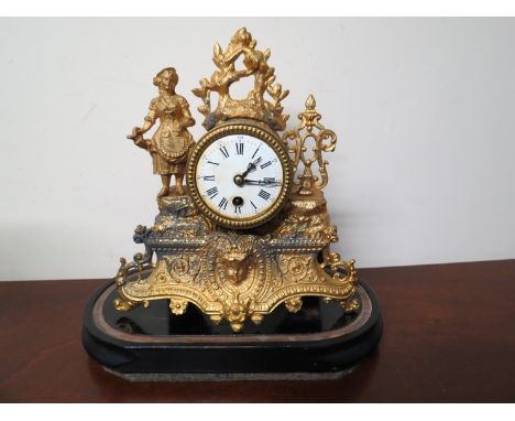 A late 19th Century French gilt ormolu clock with circular white enamel face, under glass dome 