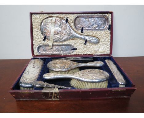 A cased set of silver dressing table items including hair brushes, mirror, pin trays, comb and associated button hook 