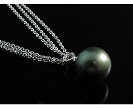 A modern large black pearl pendant hung from two graduated diamonds together with long slender white metal chain, stamped 750