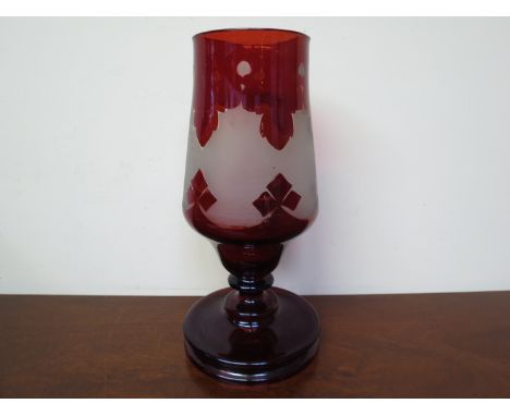 An Edwardian ruby glass vase with etched repeating pattern, 27.5cms tall 