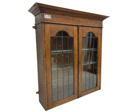 Early 20th century oak bookcase top, projecting moulded cornice over plain frieze, two arched lead glazed doors with stained 