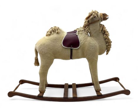 Mid-to-late 20th century child's rocking camel, upholstered in cream wool blend fabric, the body with thick shaggy mane and t