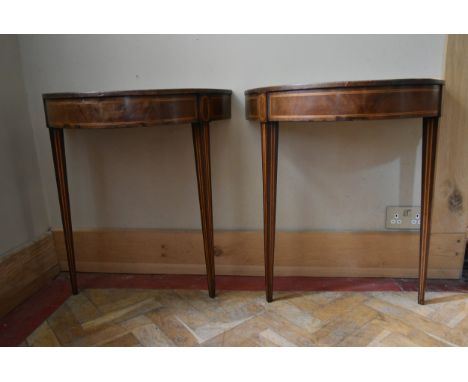 A pair of 19th century mahogany and satinwood strung demi lune console tables with inset leather tops raised on square taperi