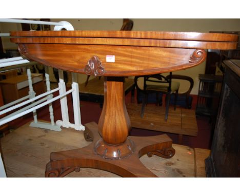 A William IV mahogany and rosewood crossbanded  card table, the D shaped fold-over top revealing a baize lined playing surfac