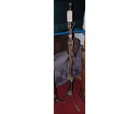 An early 20th century Eastern style telescopic brass standard lamp, on spiral turned column and splayed feet, with lion paw t