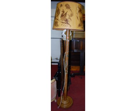 A mid-20th century beech standard lamp, having carved and painted palm tree decoration, with later shade