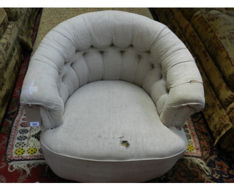 A 20th century tub chair, button back upholstered in a distressed stone coloured fabric, raised on turned legs and casters. H