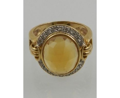 A 14 carat yellow gold, diamond, and citrine cocktail ring, the faceted oval cut central citrine surrounded by small diamonds