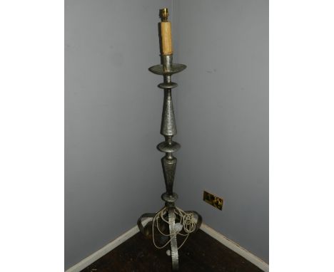 A cast metal candlestick, converted to electricity, raised on tripod base. H.148cm