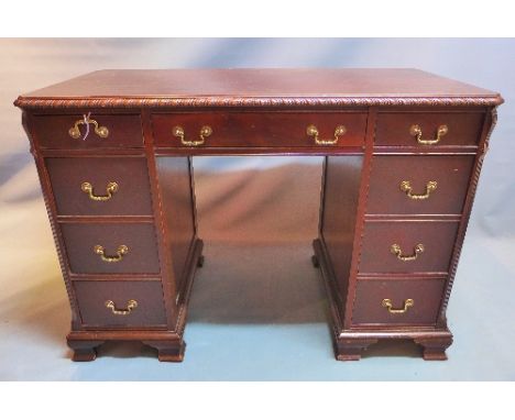 A 20th Century mahogany kneehole desk having nine drawers on bracket feet, H:76cm W:109cm D:55cm