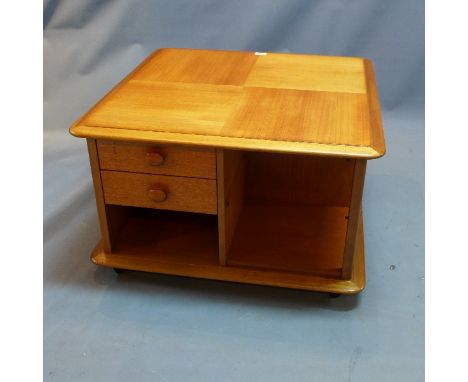 A mid 20th Century teak coffee table with two drawers, one cupboard door and shelf space raised on castors, H:46cm W:76cm D:7