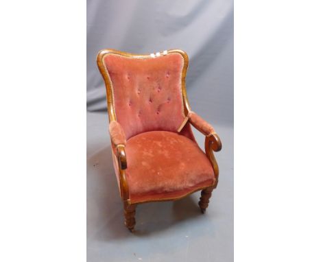 A late 19th century walnut armchair, button-back velour upholstery, on turned legs raised on castors