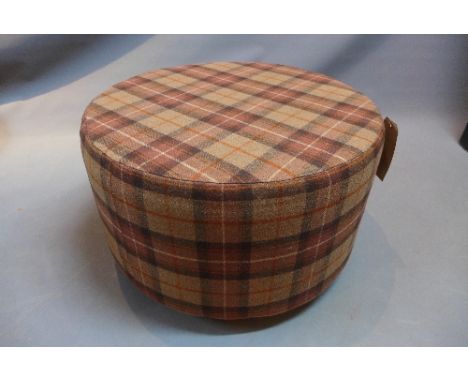 A contemporary pouffe with tartan upholstery.  