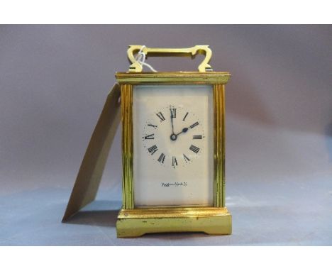 A 20th Century Mappin and Webb brass carriage clock in the regency taste having bevelled glass panels. 