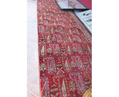 A large Northwest Persian style carpet with floral tile design on a red ground contained by many borders (a/f). 330x252cm 