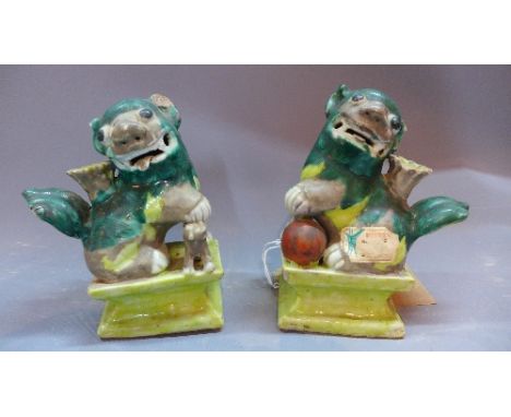 A pair of early 20th Century Chinese porcelain dogs of fo having wax seal stamps.  