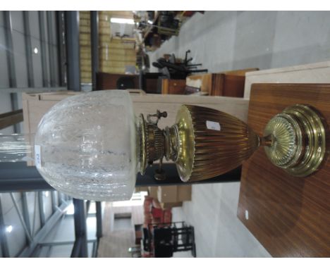 A brass oil lamp with glass shade and chimney