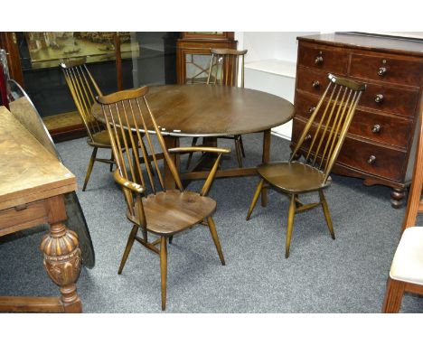 An Ercol dropleaf dining table with two carvers and two diners