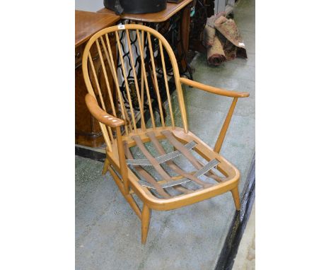 A light Ercol open arm chair with spindle back 