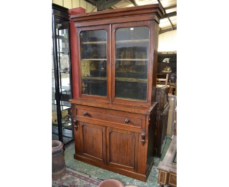 A Victorian mahogany secretaire bookcase, outswept cornice, two glazed doors enclosing velvet lined shelving, projecting base