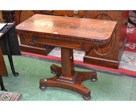 An early 19th century mahogany card table, rounded square fold over top enclosing circular green baize playing surface, sprea