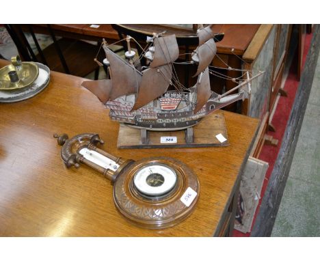 An Edwardian carved wall mounted aneroid barometer thermometer, cream/white scales; a wooden model of the Mayflower