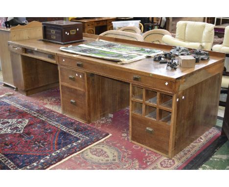 An oak three pedestal draughtsman's desk, galleried two piece top, three drawers to frieze, assortment of drawers, cupboards 