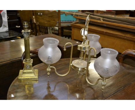 A brass Corinthian column table lamp and a brass chandelier with three etched glass shades