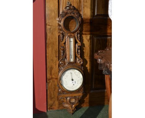 A Victorian oak barometer, 19cm circular white enamel dial, the case carved profusely with garlands and foliage, 103cm high, 