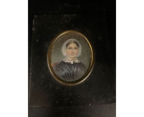 A miniature portrait of a lady with white bonnet and black dress