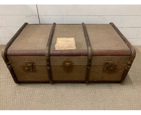 A wooden and metal bound travel trunk