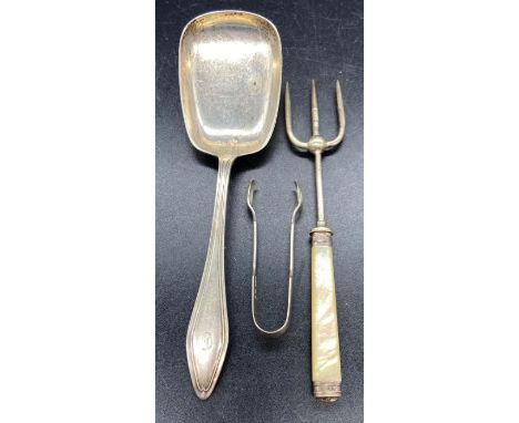 A silver set of sugar tongs, silver serving spoon and a silver and mother of pearl handled fork