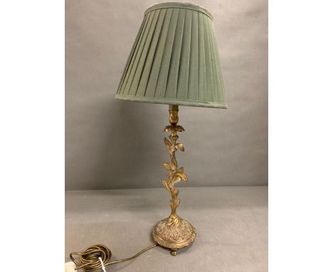 A brass table lamp with centre stem floral foliage on out swept legs 