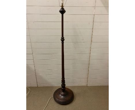 A mahogany stand lamp with turned centre support on circular base 
