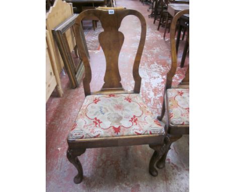 A pair of early 18th Century style walnut dining chairs each with scrolled toprail, vase splat, drop in tapestry seat and she