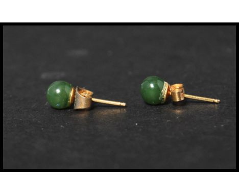 A pair of vintage 9ct gold and jade stud earrings. Jade stone beads set to gold post backs. Weighs 1.1 grams.