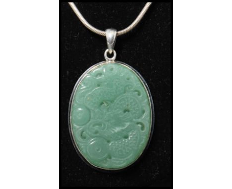 A 925 silver pendant necklace strung with a carved jade pendant with dragon decoration strung on a snake link&nbsp; chain. Me